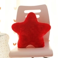 Modern red star-shaped plush pillow on a white chair with soft lighting and cozy setting - Red Pentagram