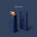 Mini five-fold compact umbrella in Deep Sea Blue with a metallic gold handle and phone for scale - 6-Rib Black Glue UV Gold Handle / Navy Blue