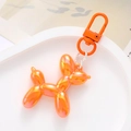 Detail of an orange gradient acrylic balloon dog keychain on a white display tray - Orange