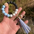 Detailed shot of light blue and white silicone bead keychain with a purple tassel charm - Light Blue