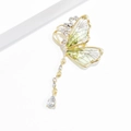 Détail d'une broche papillon vintage avec ailes émaillées vertes, glands dorés et cristal - Vert