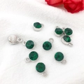 Nine green birthstone charms with silver settings on white textured fabric background - Antique Silver May - Dark Green
