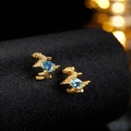 Macro shot of gold-plated striped earrings featuring round-cut blue topaz stones - Gold Natural Topaz Stud Earrings