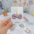 Close-up of pink glitter bow hair clip with golden unicorn horn on a display card - Light Pink Bow with Gold Horn