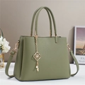 Dettaglio della borsa tote in pelle martellata verde oliva con ciondolo floreale d'oro - Verde