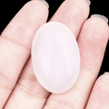 Handheld view of a polished oval translucent white crystal stone cabochon for jewelry DIY - White Jade