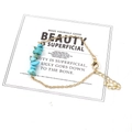Detalle de pulsera de cadena dorada con piedras de turquesa en una tarjeta de exhibición - Turquesa Azul
