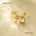Detailed view of a gold heart ring with bow and zircon on a textured background - Bowknot Heart Zircon Gold Ring (NMSR-H3110-1)