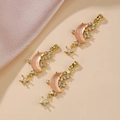 Three gold star and pink resin moon pendants with micro-set zircon stones in a group - Pink