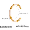 Macro detail of gold PVD plated stainless steel C-shape bangle with white enamel inlay - Lotus Pink Enamel Striped Style (Z330)