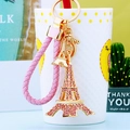 Detail of Eiffel Tower keychain with pink rhinestones and a braided cord on a decorative cup - Pink Rope + Pink Eiffel Tower