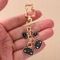 Detail of golden heart cat keychain with four cute black cat pendants on hand - Black Cat