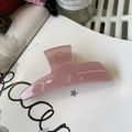 Pink translucent acrylic shark hair claw clip on fashion book in natural light - Jelly Pink