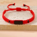Detail of red and black woven bracelet with black rectangular plate on a stone background - Red (Black Plate)