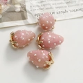 Pink resin strawberry pendants with white dots and gold leaf caps on vintage paper - Pink