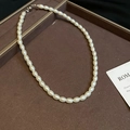 Detail of elegant pearl necklace with oval beads and spherical clasp on velvet tray - White-Oval 6mm