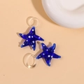 Detailed close-up of dark blue glass starfish pendants with white polka dots for jewelry - Blue
