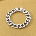 Detail of silver Cuban link bracelet with lobster clasp on a textured background - Polished Steel (KB27123-D)