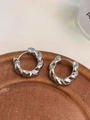 Chic silver twisted rope hoop earrings with a metallic teardrop texture on a tray - Silver Thick Braided Ear Buckle