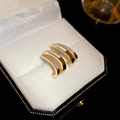 Detail von goldenen C-förmigen Ohrringen mit Muschel-Inlay und Zirkonia in einer Box - Kupfer/S925 Silbernadel/Zirkonia / Gold