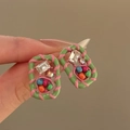 Detailed macro view of square crystal stud earrings with colorful enamel spiral design - Green-Pink-Square