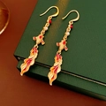 Dettaglio di orecchini vintage koi in smalto con nappe dorate e perle su scatola verde - Stile Gancio / Oro