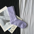 Ribbed knit crew sock in vibrant purple displayed on an open magazine over monochrome fabric - Short Light Purple