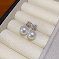 Primer plano de pendientes de perlas con circonitas sobre un joyero de terciopelo beige - Pin de Plata S925 / 10mm / Blanco