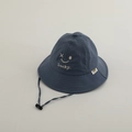 Detail of navy quick-dry sun hat with white Lucky face embroidery and adjustable wind cord - Closed Eyes Smiley / Blue