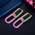 Macro detail of gold geometric hoop earrings with pink and green pavé zircons - Red Green Mixed