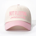 Detailed close-up of pink and beige baseball cap featuring Not Flirting embroidery - Adjustable / Off-white and Pink