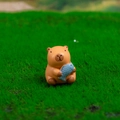 Resin Capybara figurine holding a blue fish on green grass for desktop decor - No. 2 Holding Fish
