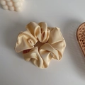 Elegant champagne gold satin scrunchie with a glossy silk texture for hair styling - Champagne