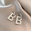 Silver metal letter B geometric earrings displayed on elegant champagne satin fabric - Letter B Drop Earrings - Silver