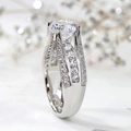 Elegant four-prong round cut diamond ring with triple-row pavé band in silver finish - US 7 / White Gold
