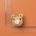 Handmade brown knitted bear head charm measuring 5cm wide on an orange background - Brown Knitted Bear Head
