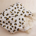Detail of soft muslin baby blanket featuring leopard print and delicate lace fringe - 100x120cm / White Leopard Print