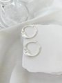 Macro detail of silver moon hoop earrings with carved face and crystal eye accent - Matte Silver