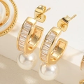 Close-up of golden C-shaped earrings featuring baguette zircons and white pearls - Square Zirconia Earrings (ES2320-2)