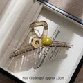 Detalle de pinza para el pelo de 13cm color champán con flor, perla y strass fino - Pinza de perlas con flores amarillas pálidas grandes