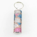 Makro-Detail des Camouflage-Strass-Mini-Pillenbehälters mit Schlüsselanhänger vor weiß - Fischmuster