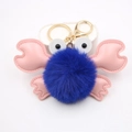 Close-up of blue pompom crab keychain with pink leather claws and a gold metal clip - Sapphire Blue
