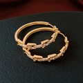 Primer plano de pendientes de aro de cadena chapados en oro 18K con circonitas engastadas - Pin de Plata - Chapado en Oro Real / Dorado