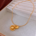 Close-up van matte gouden halsketting met patroonring en ronde kraalhangers - Gouden Gelukstas & Ring Stijl