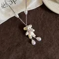 Detailansicht der Perlenkette mit weißem beflocktem Bärenanhänger und rosa Schleife - Weiß (Silberne Kette)