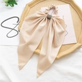 Detail of champagne satin bow scrunchie with sparkling rhinestone center on elegant tray - Rhinestone Waist Buckle Style / Beige