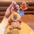 Close-up of brown capybara plush keychain with red backpack and metal bell detail - Capybara with Basketball