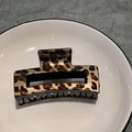 Macro detail of rectangle leopard print hair claw clip on white ceramic plate - Dark Yellow Leopard