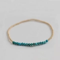 Macro detail of elastic beaded bracelet with gold round beads and turquoise stone accents - Phoenix Turquoise