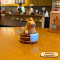 Süße Capybara-Figur aus Harz beim Baden im Holzzuber mit einer Orange auf dem Kopf - Badendes Capybara